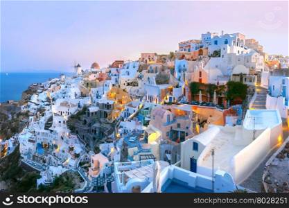 Panoramic famous view, Old Town of Oia or Ia on the island Santorini, white houses and windmills at dawn, Greece