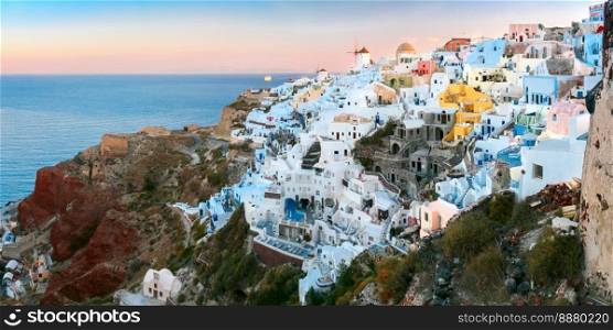 Panoramic famous view, Old Town of Oia or Ia on the island Santorini, white houses and windmills at dawn, Greece. Oia at sunset, Santorini, Greece