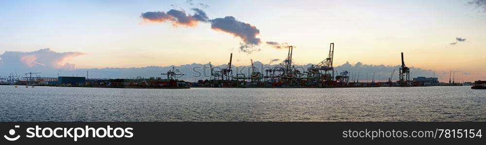 Panoramic image of a commercial harbor area at dusk on a very quiet day