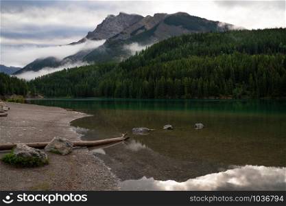 Panoramic image of mountain peak reflecting in Two Jack Lake with early morning mood, Banff National Park, Alberta, Canada
