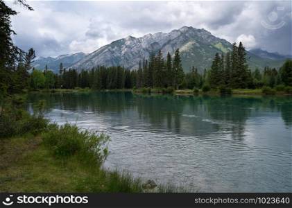 Panoramic image of the tranquil Bow river close to Banff with cloudy sky, Banff National Park, Alberta, Canada