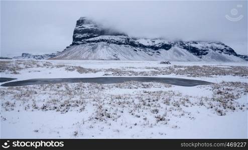 Panoramic landscape along the southern coast of Iceland with snow-covered mountains