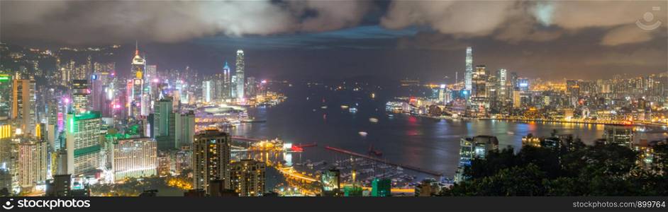 Panoramic landscape or cityscape of Hong Kong island, Victoria harbour, and Kowloon city at night, view from Red incense burner summit. Asia travel destination or Asian tourism concept, banner size