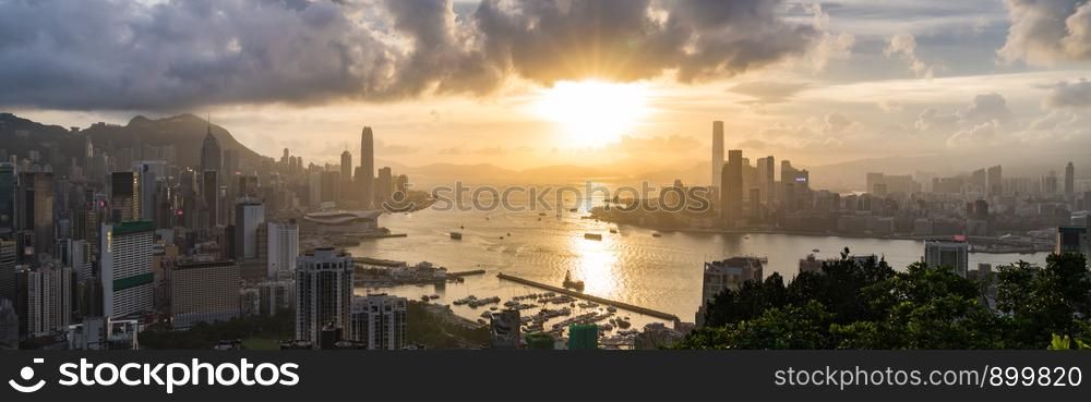 Panoramic landscape or cityscape of Hong Kong island, Victoria harbour, and Kowloon city at sunset, view from Red incense burner summit. Asia travel destination or Asian tourism concept, banner size