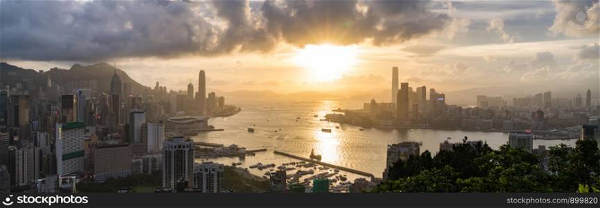 Panoramic landscape or cityscape of Hong Kong island, Victoria harbour, and Kowloon city at sunset, view from Red incense burner summit. Asia travel destination or Asian tourism concept, banner size
