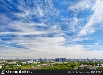Panoramic modern city skyline aerial view, daytime view with city skyscrapers under beautiful blue sky in Kyiv, Ukraine.. Panorama of the city under a high beautiful blue sky with light white curly clouds.