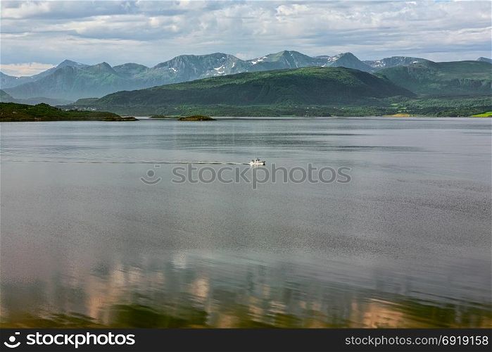 Panoramic mountain view with a boat sailing in the fjord in Molde, Norway. Mountain view and fjord in Molde, Norway