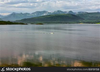 Panoramic mountain view with a boat sailing in the fjord in Molde, Norway. Mountain view and fjord in Molde, Norway