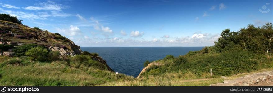 Panoramic ocean view wedged in between two hills and a steep cliff