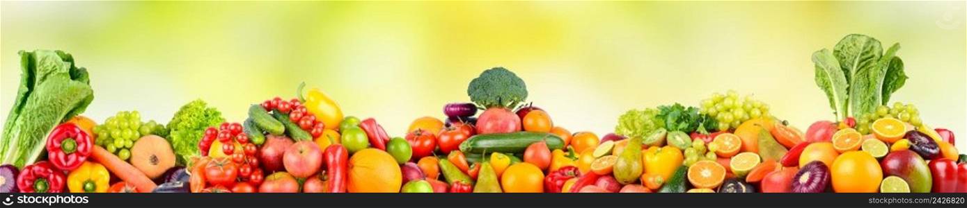 Panoramic photo fruits and vegetables on green natural blurred background. Free space for text.
