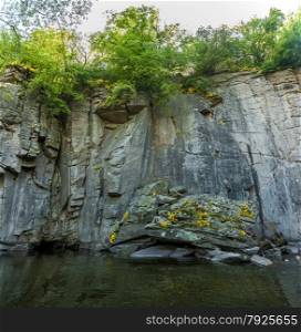 Panoramic photo of high rock wall on mountain river