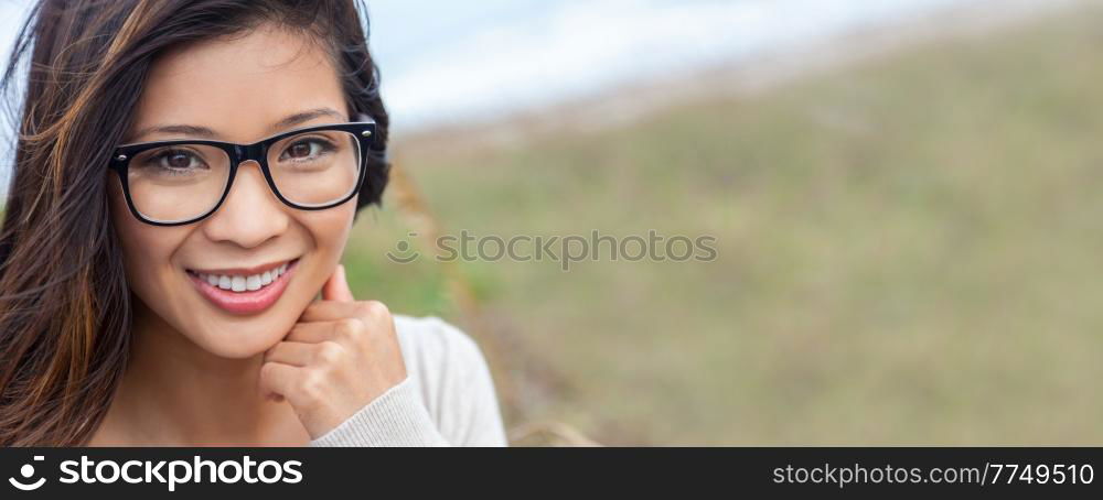 Panoramic portrait of a beautiful chinese asian girl or young woman with perfect teeth outside wearing glasses. Panorama web banner header.