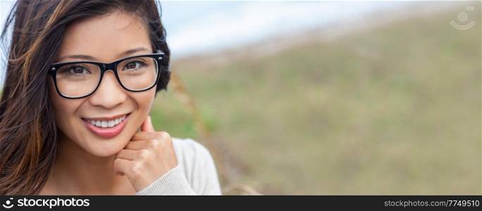 Panoramic portrait of a beautiful chinese asian girl or young woman with perfect teeth outside wearing glasses. Panorama web banner header.