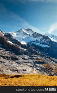 Panoramic scenery of rock cliff and Jungfrau peak view from Kleine Scheidegg station, Jungfrau region, Switzerland