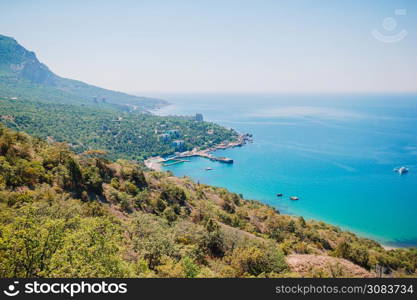 Panoramic seascape, calm azure sea, beach and bright sky. View of the Black Sea coast in Crimea. Beautiful nature with with azure bay, sea and blue sly