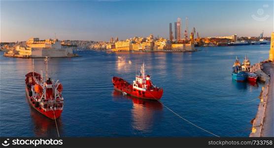 Panoramic skyline view of ancient defences of Valletta and the Grand Harbor with ships and Three cities, three fortified cities of Birgu, Senglea and Cospicua, at dawn. Malta.. Valletta and the Grand Harbor at dawn. Malta.