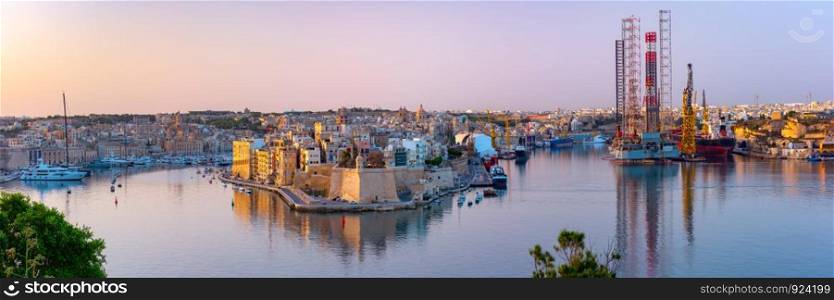 Panoramic skyline view of ancient defences of Valletta, the Grand Harbor and Three cities, three fortified cities of Birgu, Senglea and Cospicua, at dawn, Valletta, Malta.. Valletta and the Grand Harbor at dawn. Malta.