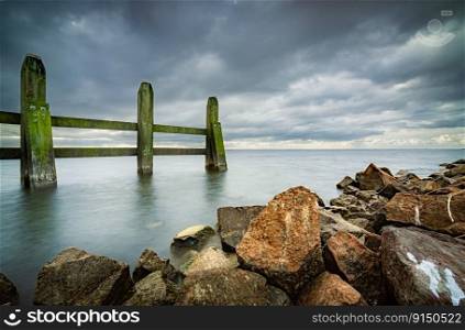 Panoramic view al dutch lake from a pier at the harbor in  village Urk at Flevoland, Netherlands. Jetty and breakwater in stormy skies with a view over the IJsselmeer lake