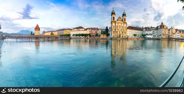 Panoramic view facades of old medieval houses on the city embankment at sunrise. Lucerne. Switzerland.. Lucerne. Old city embankment and medieval houses at dawn.