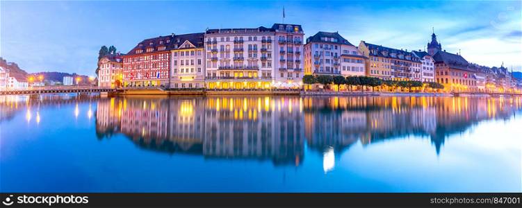 Panoramic view facades of old medieval houses on the city embankment at sunrise. Lucerne. Switzerland.. Lucerne. Panorama. Old city embankment and medieval houses at dawn.