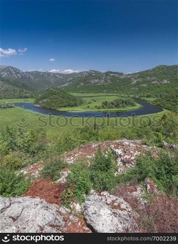 Panoramic view from above of Skadar lake and Crnojevica river in a national park, Montenegro, in a sunny summer day. Skadar lake and Crnojevica river in Montenegro
