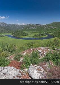 Panoramic view from above of Skadar lake and Crnojevica river in a national park, Montenegro, in a sunny summer day. Skadar lake and Crnojevica river in Montenegro
