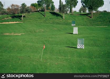 Panoramic view of a golf practice course with signs of meters reached.