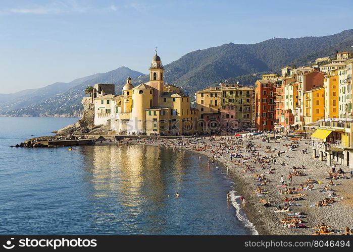 Panoramic view of a seaside town in the foreground beach an church in the background on a sunny day