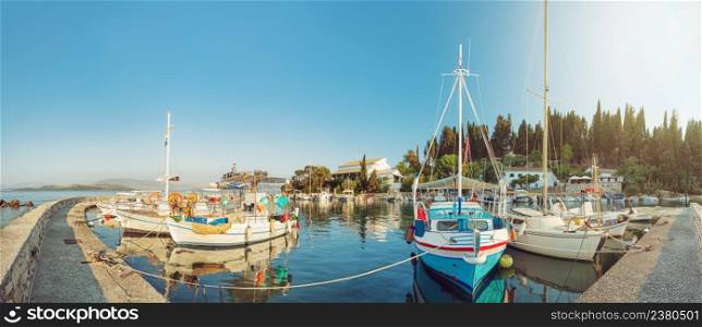 Panoramic view of colorful fishing boats docked in the harbor of Kalami, Corfu island, Greece