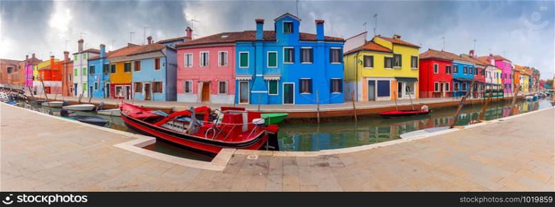 Panoramic view of colorful houses along the canal on the island of Burano. Burano. Italy. Venice.. Panorama. Facades of traditional old houses on the island of Burano.