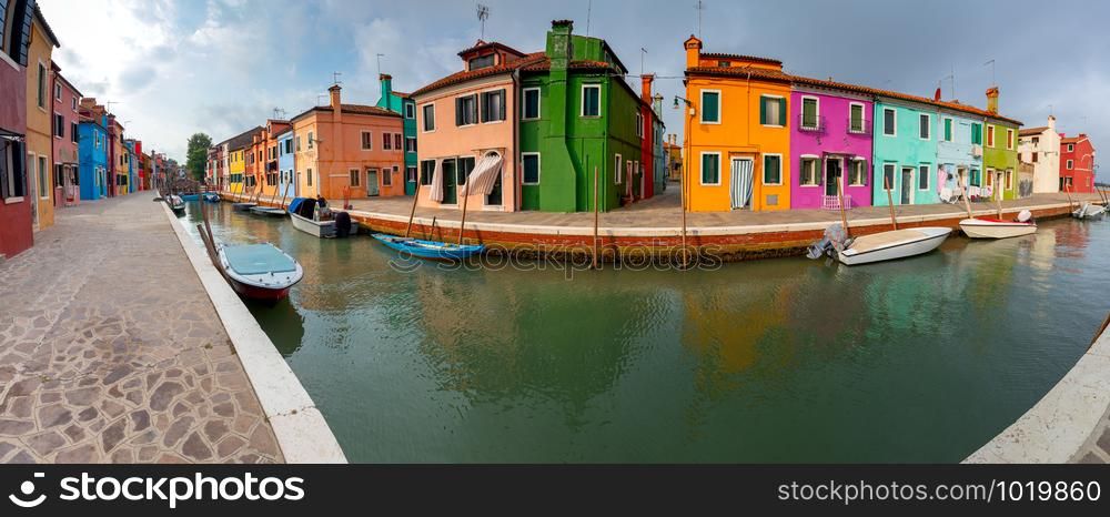 Panoramic view of colorful houses along the canal on the island of Burano. Burano. Italy. Venice.. Panorama. Facades of traditional old houses on the island of Burano.