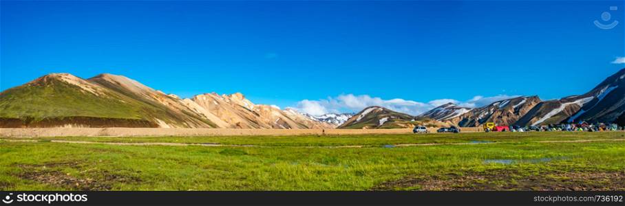 Panoramic view of colorful volcanic Landmannalaugar region and camping site at blue sky in Iceland, summer time, dramatic scene
