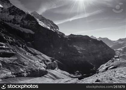 Panoramic view of deep valley and cottage on cliff near Kleine Scheidegg Hiking trail, Jungfrau region, Switzerland