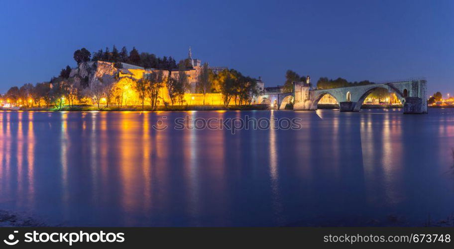 Panoramic view of famous medieval Saint Benezet bridge and Palace of the Popes during evening blue hour, Avignon, southern France. Famous Avignon Bridge, France