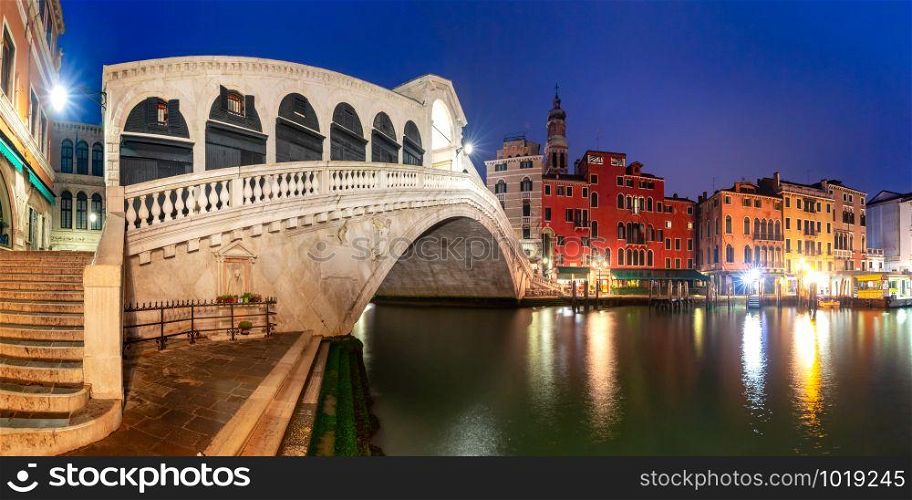 Panoramic view of famous Rialto Bridge or Ponte di Rialto over the Grand Canal in Venice at night, Italy.. The Rialto Bridge, Venice, Italy