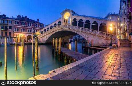 Panoramic view of famous Rialto Bridge over the Grand Canal in Venice at night, Italy.. The Rialto Bridge, Venice, Italy