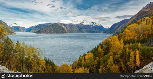 Panoramic view of norwegian fjord, autumn forests and distant snow-capped mountains from above
