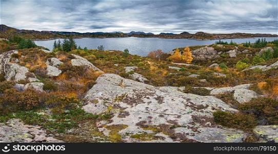 Panoramic view of norwegian rocks and fjord under gloomy sky at autumn time