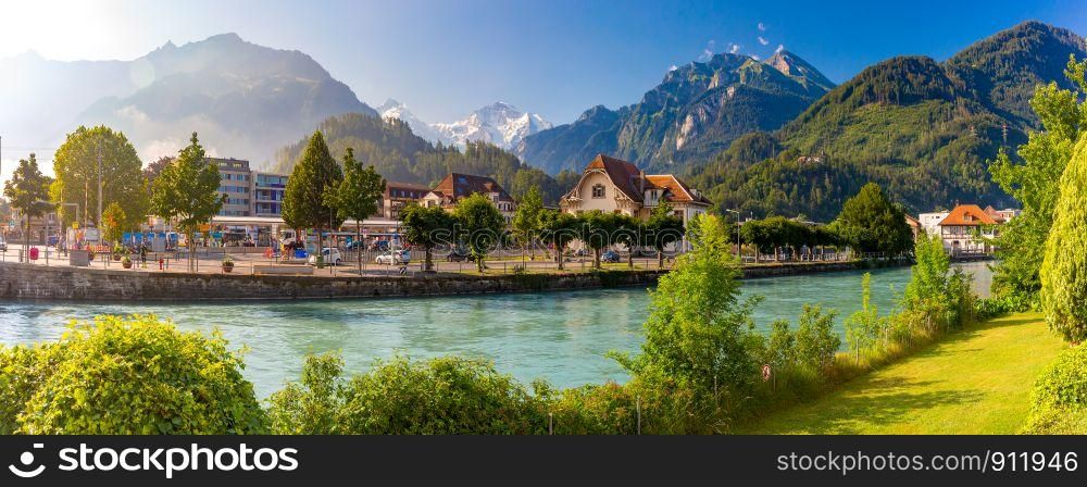 Panoramic view of Old City with thrain station and Aare river. Interlaken, important tourist center in the Bernese Highlands, Switzerland. The Jungfrau is visible in the background. Old City of Interlaken, Switzerland