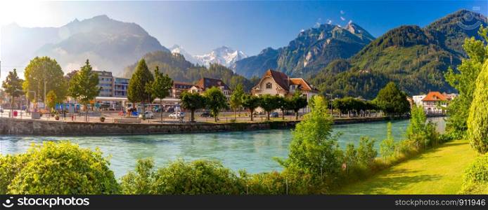 Panoramic view of Old City with thrain station and Aare river. Interlaken, important tourist center in the Bernese Highlands, Switzerland. The Jungfrau is visible in the background. Old City of Interlaken, Switzerland