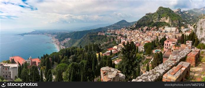 Panoramic view of Old Town of Taormina and Mediterranean sea in sunny day from Ancient Greek theatre, Sicily, Italy. Aerial view of Taormina, Sicily, Italy