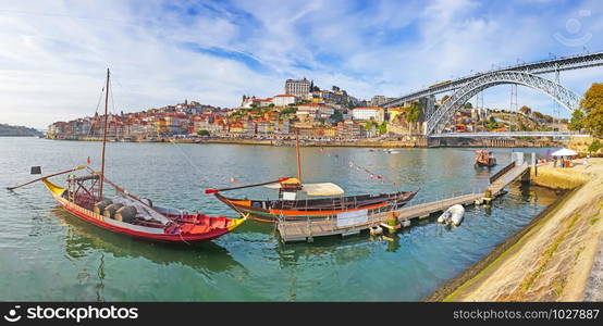 Panoramic view of old town Porto and Douro River with traditional Rabelo boats.