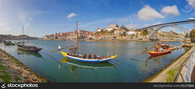 Panoramic view of old town Porto and Douro River with traditional Rabelo boats.