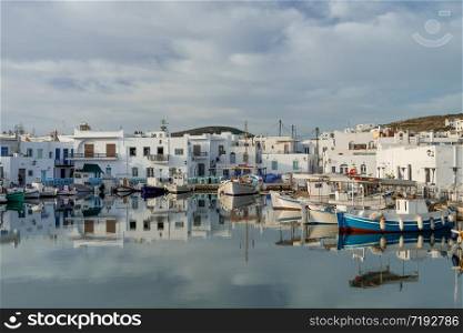 Panoramic view of Paros island popular tourist attraction, Naousa town. Promenade zone along port with restaurants and shops. Harbor of Aegean Sea, oats and yachts in quay at calm morning. Greece