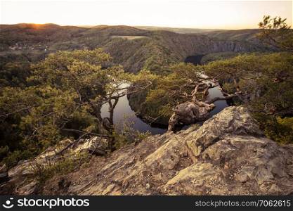 Panoramic view of river canyon with dark water and autumn colorful sunset. Horseshoe bend, Vltava river, Czech republic. Beautiful landscape with river. Maj lookout.
