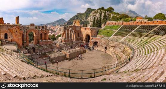 Panoramic view of Ruins of Ancient Greek theatre and Old Town of Taormina in sunny day, Sicily, Italy. Aerial view of Taormina, Sicily, Italy