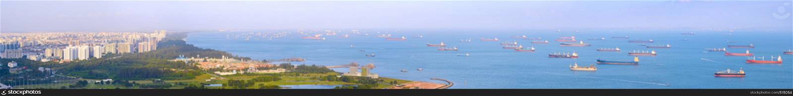 Panoramic view of Singapore harbor with many cargo ships at sunset. Singapore