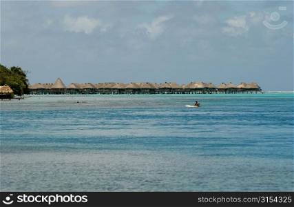 Panoramic view of thatched buildings on stilts in the sea, Moorea, Tahiti, French Polynesia, South Pacific
