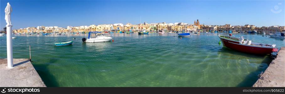 Panoramic view of the bay fishing boats and the village of Marsaxlokk. Malta.. Panorama of the harbor and village Masashlokk