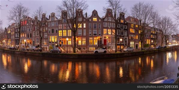 Panoramic view of the city embankment and facades of houses at sunset. Amsterdam. Netherlands.. Panorama of the city waterfront of Amsterdam at sunset.